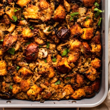 vegan mushroom stuffing in baking dish topped with fresh parsley