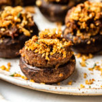 stuffed mushrooms topped with fresh herbs on white plate