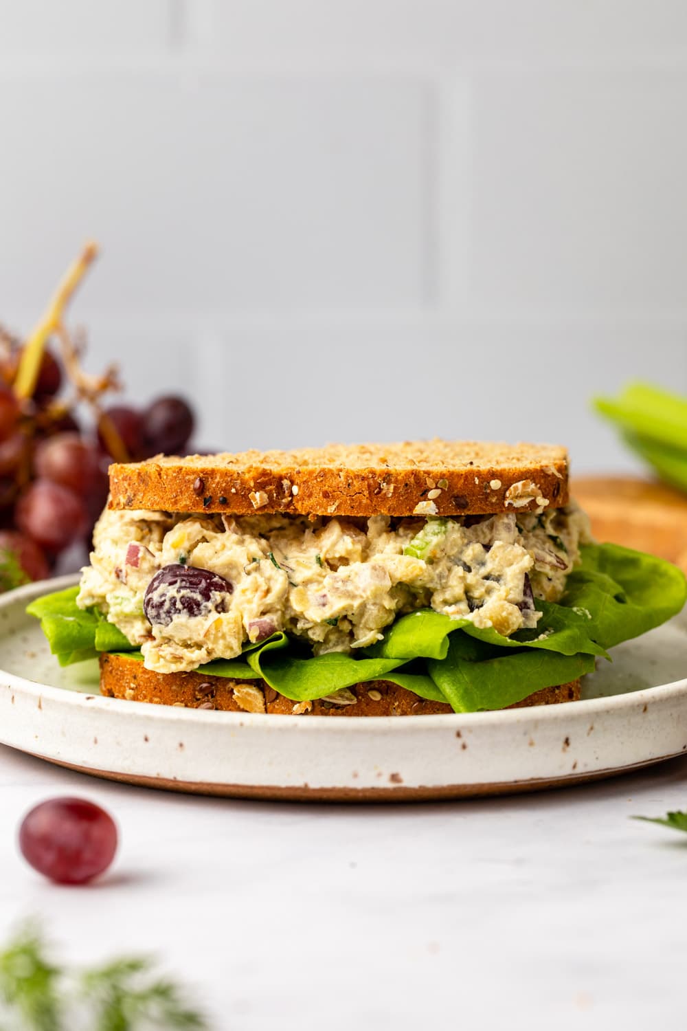 vegan chickpea salad sandwich with lettuce on white plate