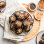 chocolate puff puff topped with toasted coconut on white plate