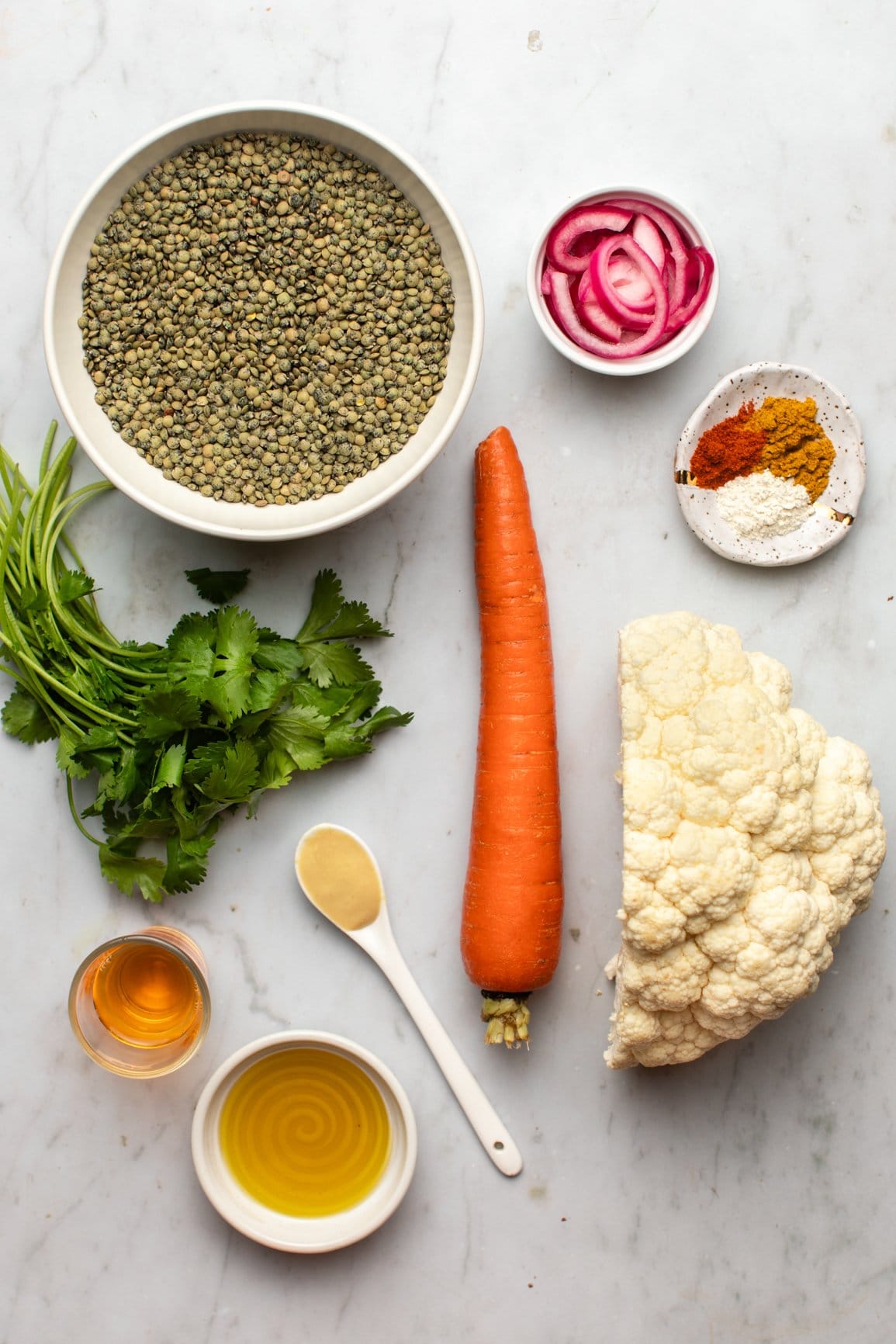 ingredients for curry lentil salad arranged on marble background