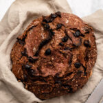 Double chocolate no-knead bread in linen napkin with bread knife