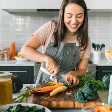 caitlin cuttting carrot on mandoline on wood cutting board