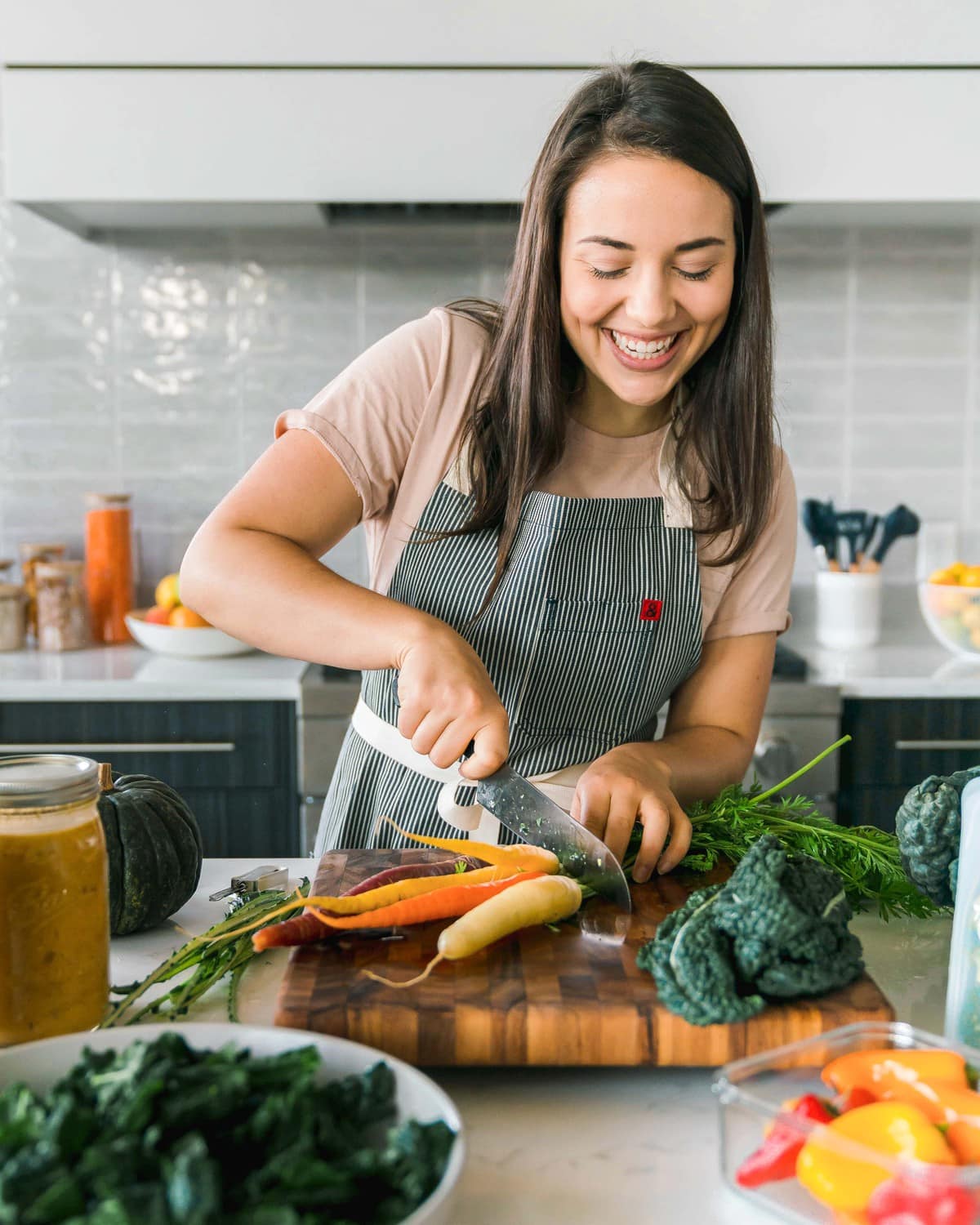 caitlin cuttting carrot on mandoline on wood cutting board