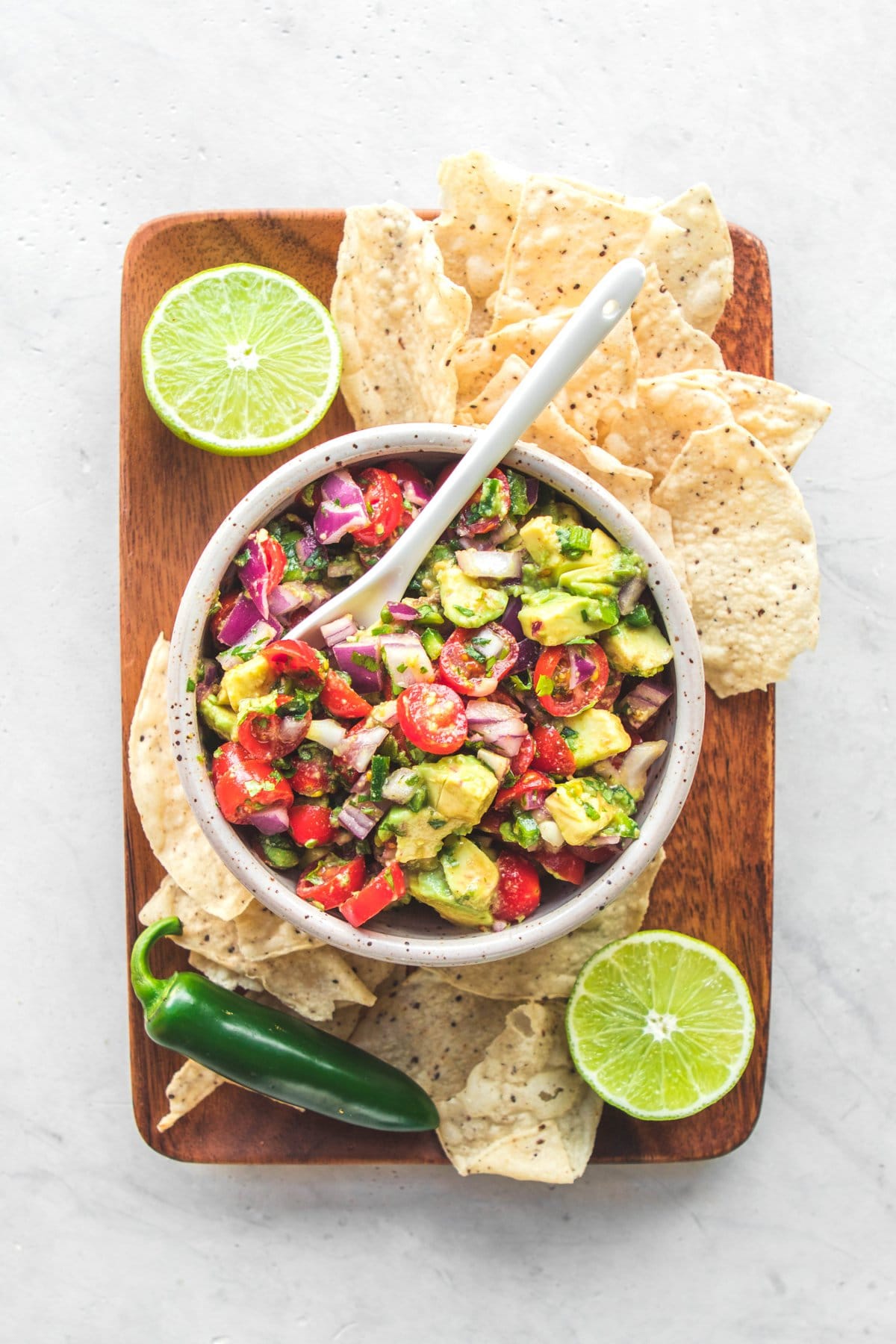 Avocado salsa on wood platter with cips