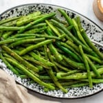 garlic green beans in speckled white dish