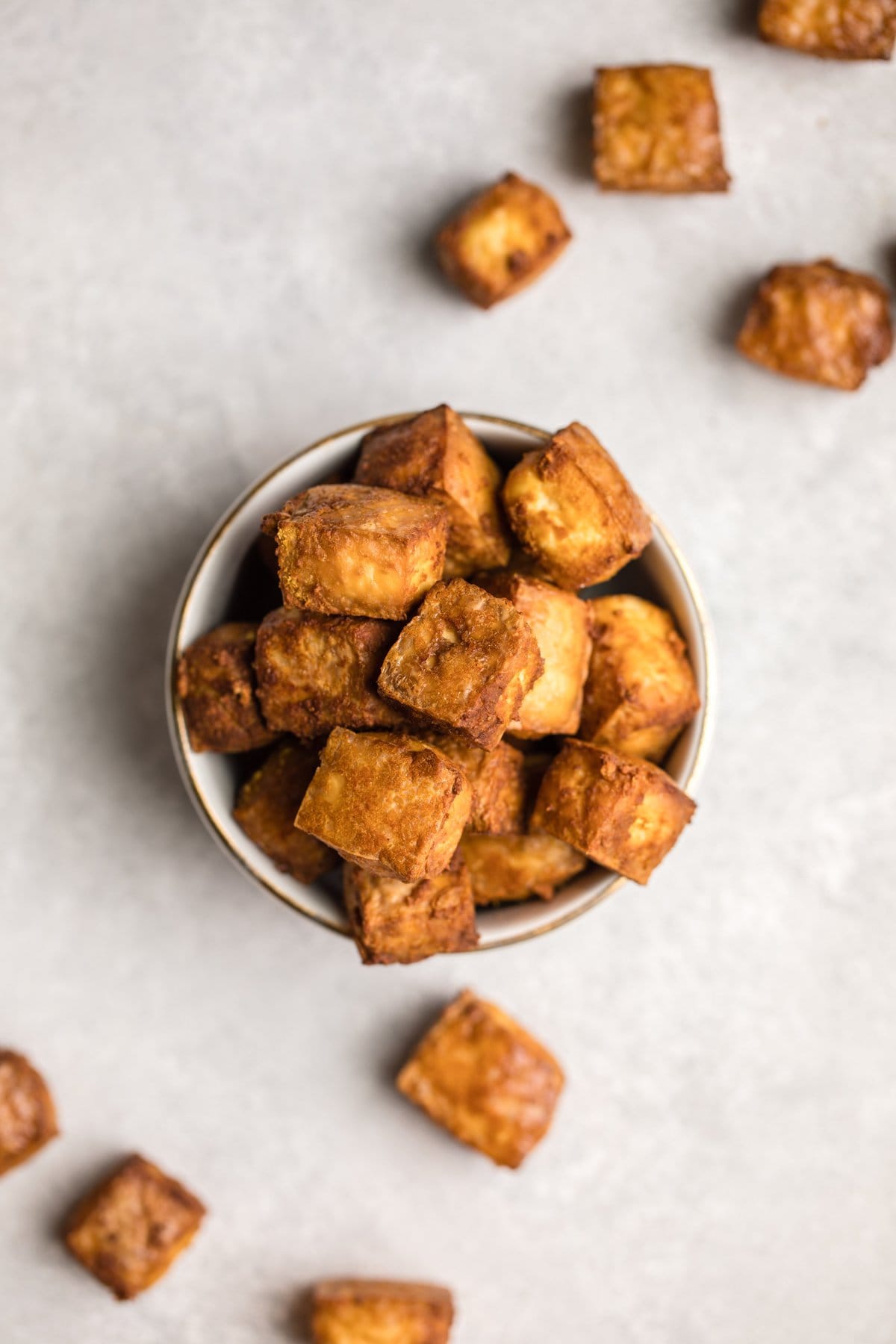 crispy tofu in white bowl on gray stone background