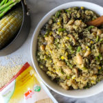 white bowl filled with asparagus mushroom quinoa and wooden serving spoon