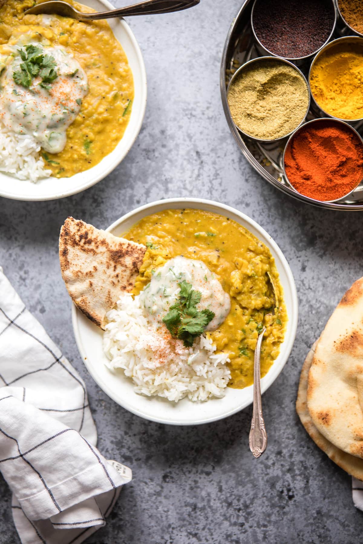 two bowls of dal tadka with rice and raita