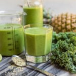 pineapple mint smoothie in glass jars on marble cutting board