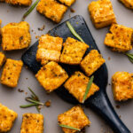 rosemary garlic tofu on baking sheet with spatula