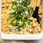 salsa verde and white bean casserole topped with cilantro vegan cheese red onion and jalapeño slices