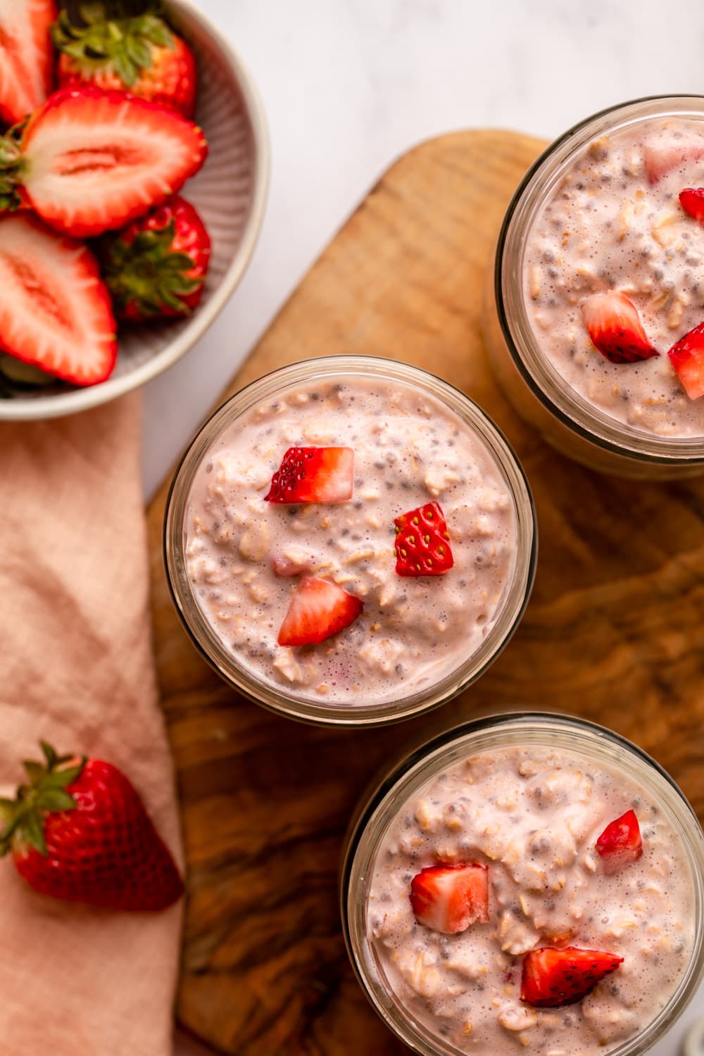 strawberry overnight oats served in small glass jars