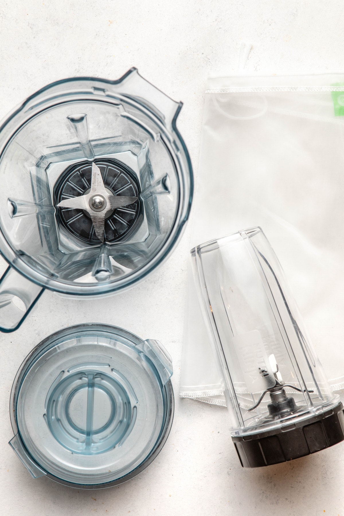blender, nut milk bag, and bullet blender on white background