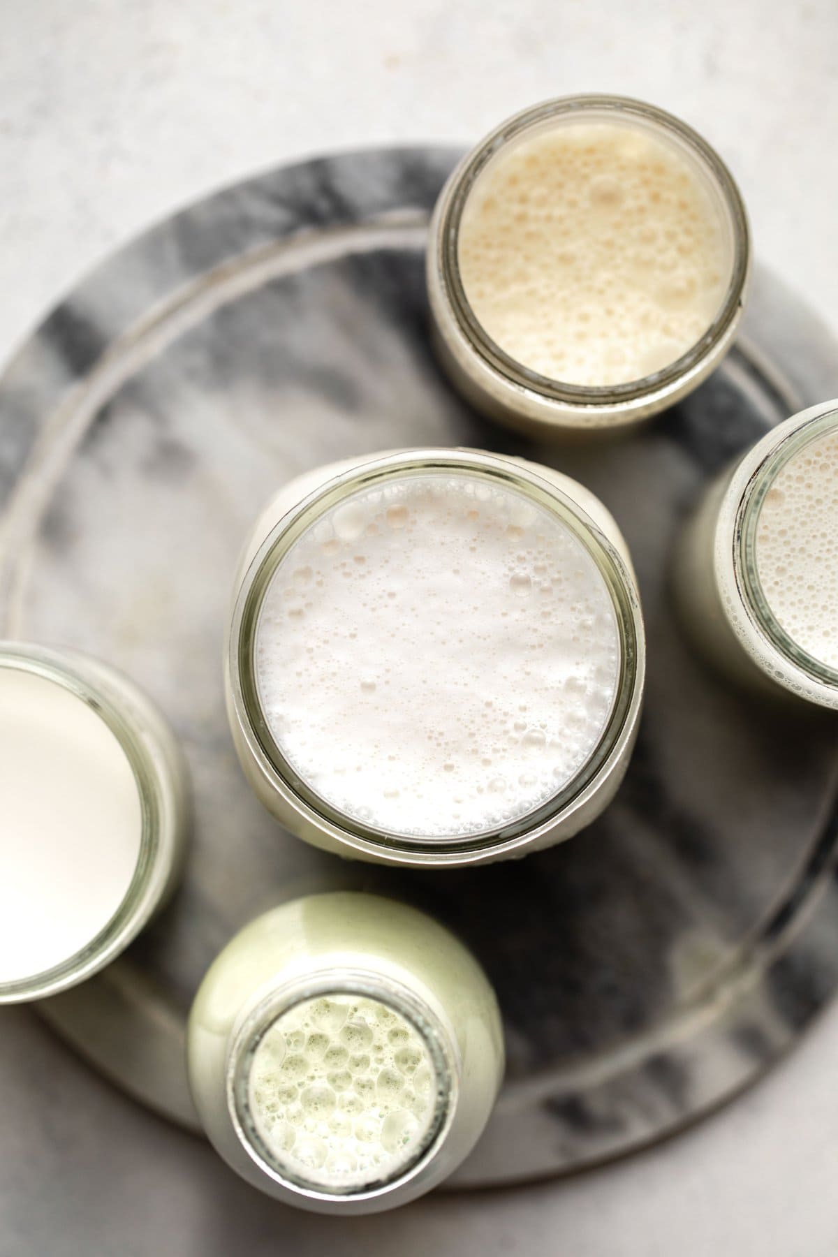 5 different jars of frothy nut milks