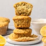 stack of 3 muffins with the top one cut in half on small white plate