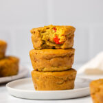 Stack of vegan egg cups with bite taken out of top cup on white plate