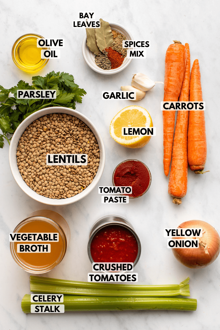 ingredients for the lentil soup laid out on a marble countertop with labels added on