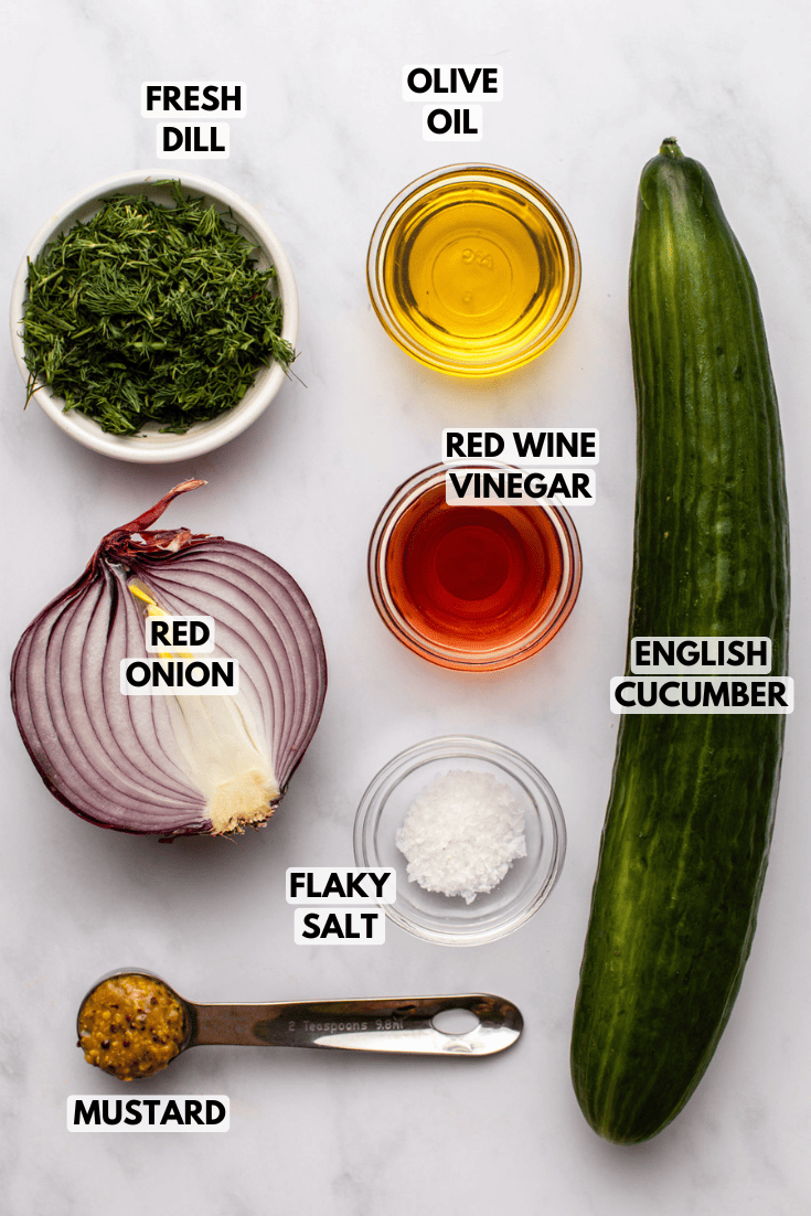 ingredients for cucumber dill salad laid out on a kitchen countertop