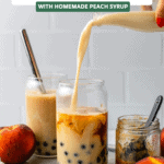 hand pouring milk into glass filled with boba and black tea