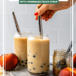 hand stirring milk into glass filled with boba and black tea