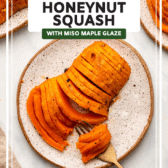 Fork slicing through roasted honeynut squash on small white plate