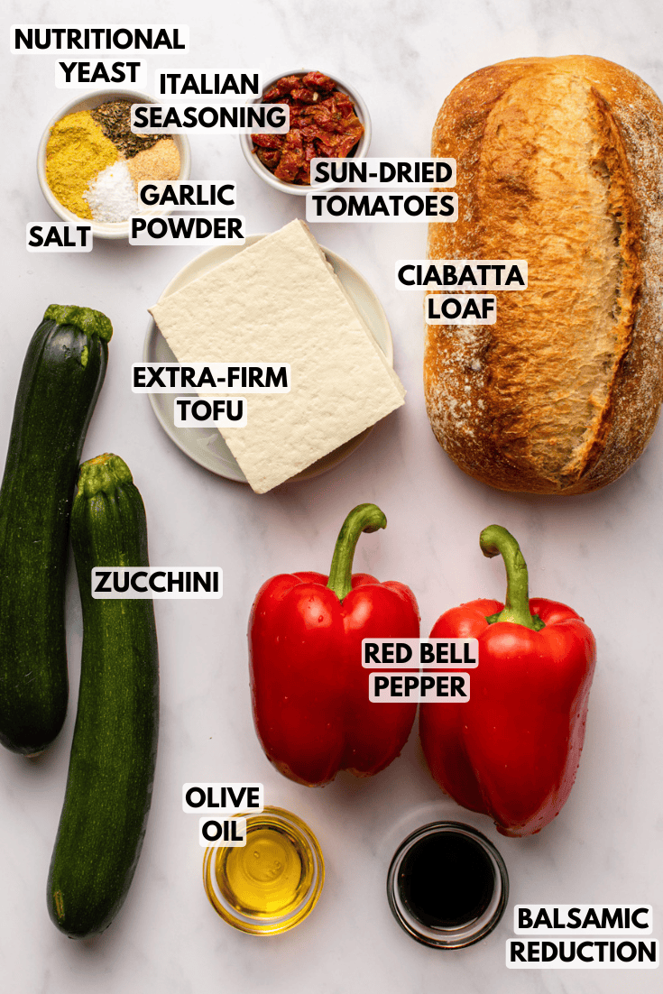 ingredients for roasted zucchini sandwich laid out on a marble kitchen countertop