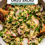 Large mixing bowl with spring orzo salad wooden serving utensils