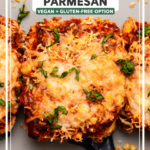 Baked tofu parmesan topped with vegan cheese and marinara sauce on baking sheet