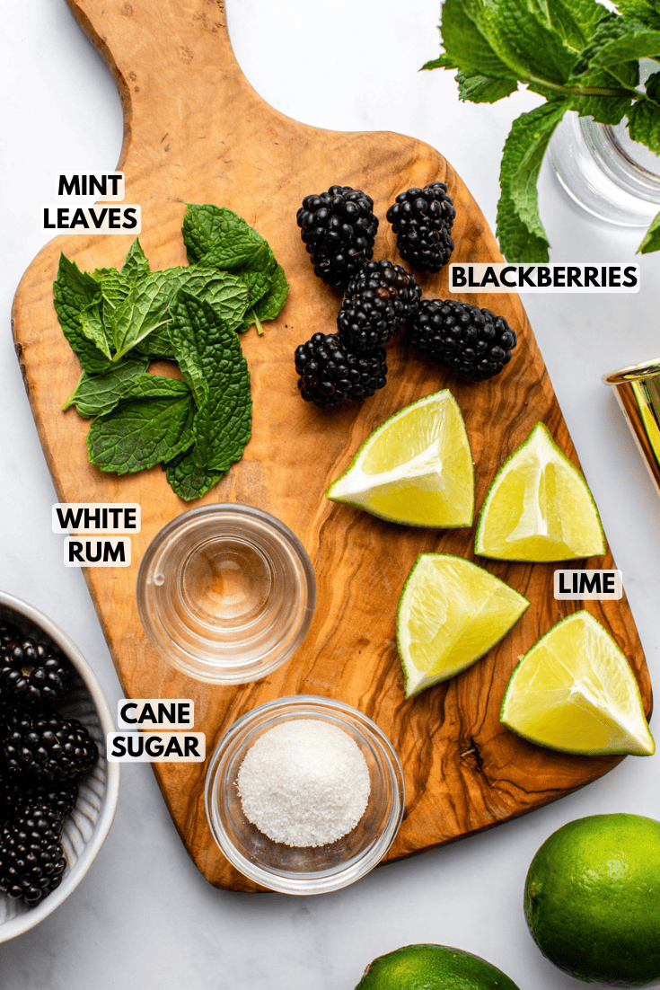 ingredients for blackberry mojito laid out on a wooden cutting board