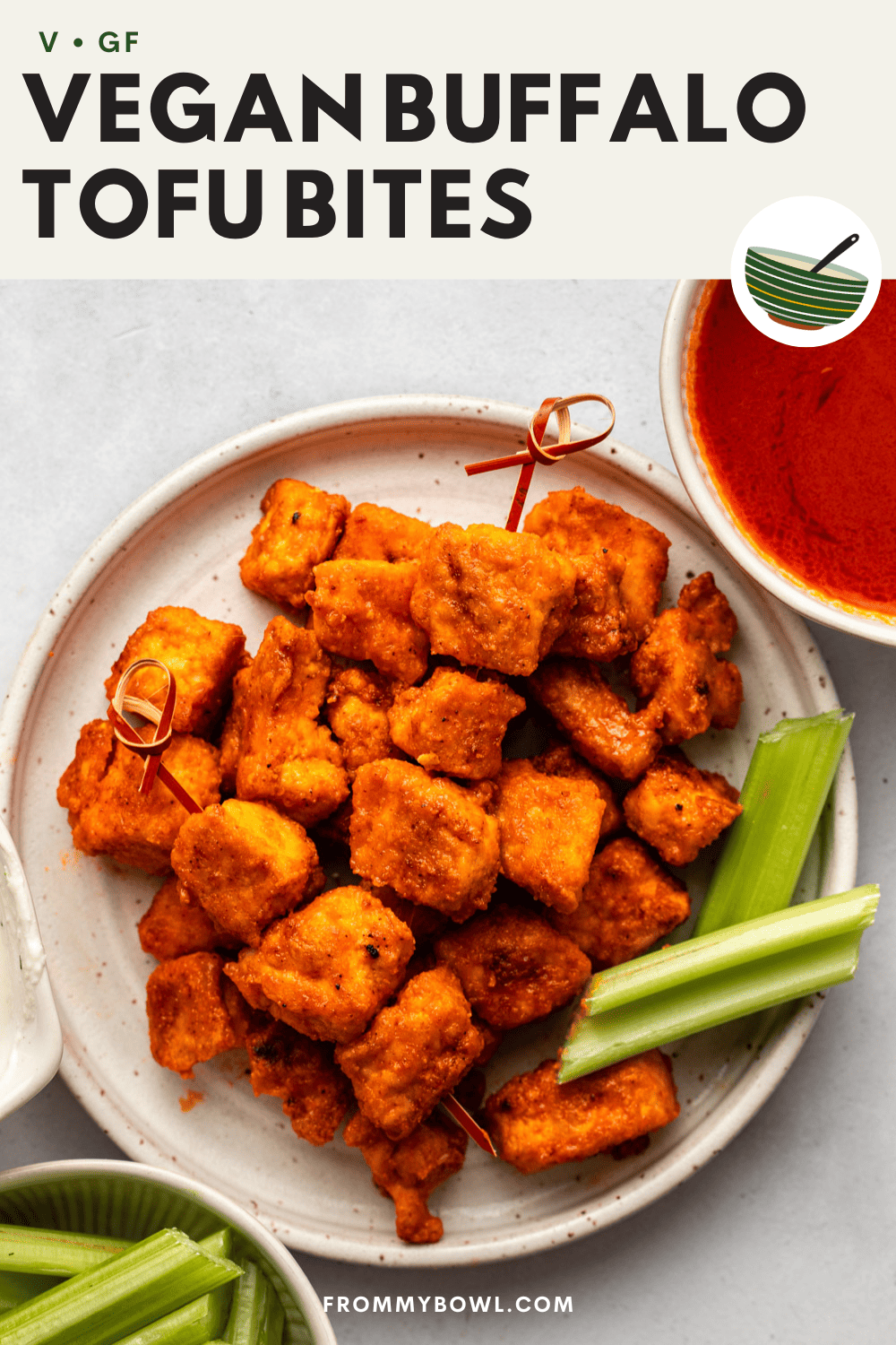 buffalo tofu bites served on a white plate with celery sticks on the side