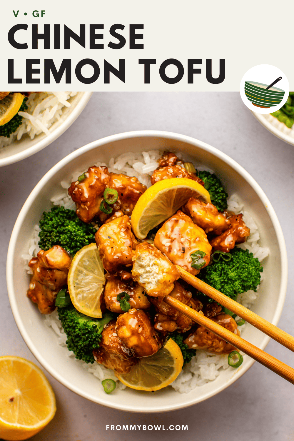 chinese lemon tofu served over rice with steamed broccoli in a white bowl, which chopsticks showing off the inner texture of tofu