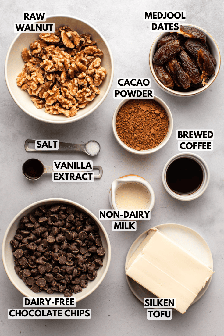 ingredients for vegan chocolate pie served in various sizes of white bowls laid out on a marble kitchen countertop