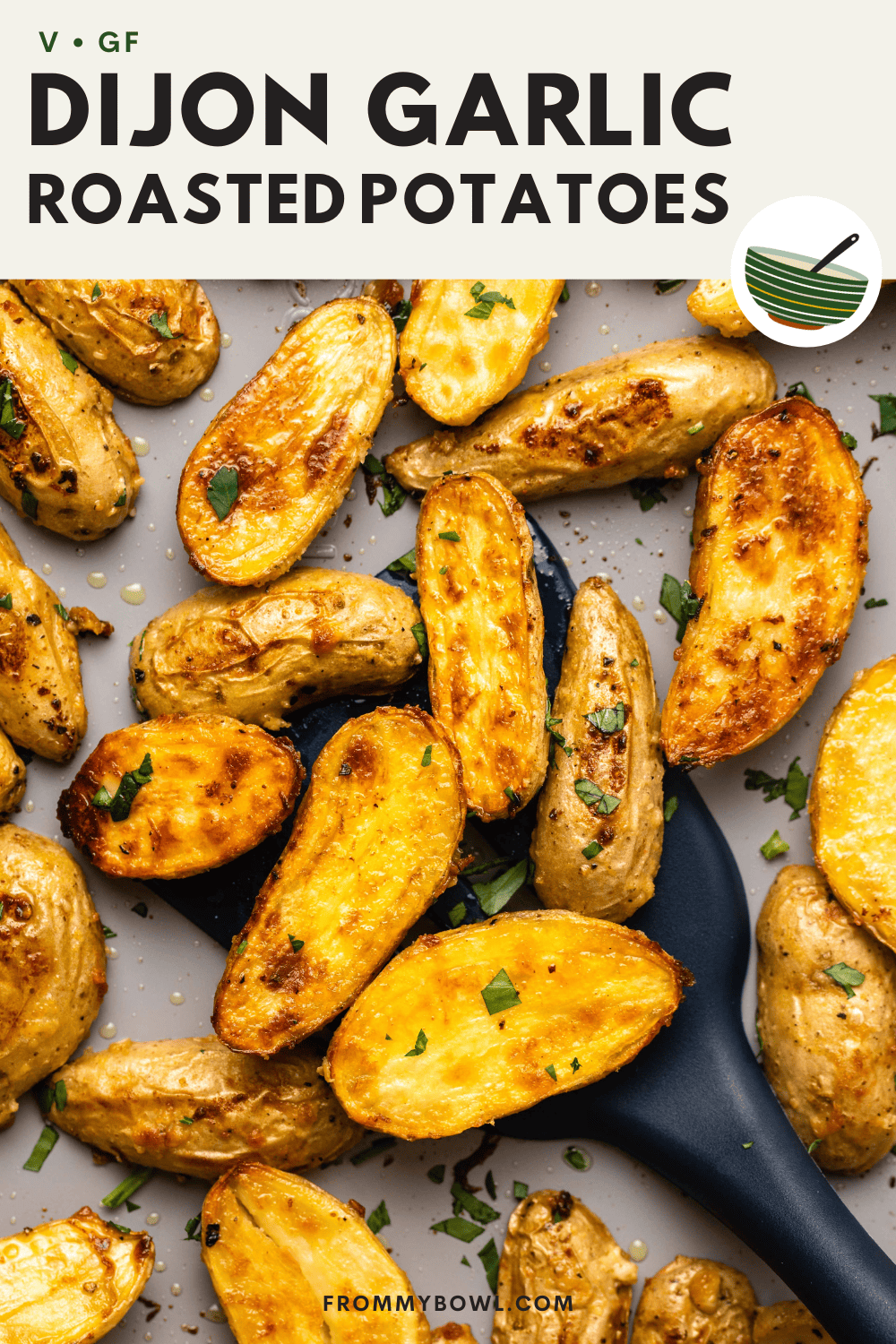 Roasted potatoes on baking sheet with spatula scooping them up