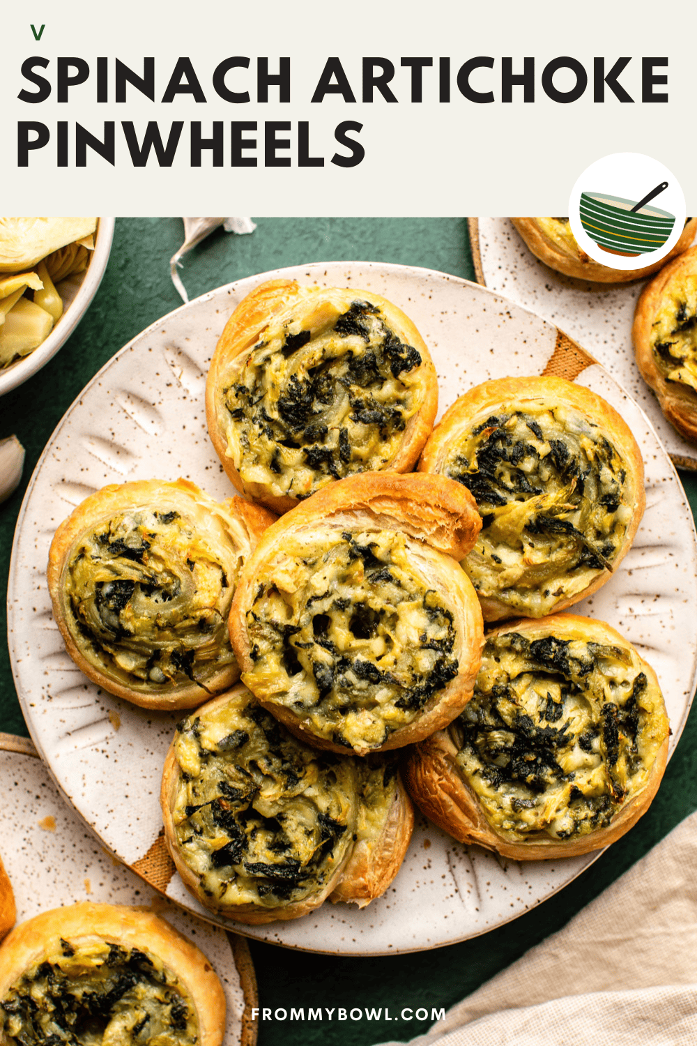 six spinach artichoke pinwheels served on a white plate