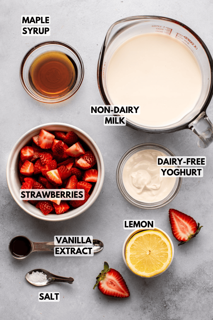 ingredients for vegan strawberry milk laid out on a marble kitchen countertop