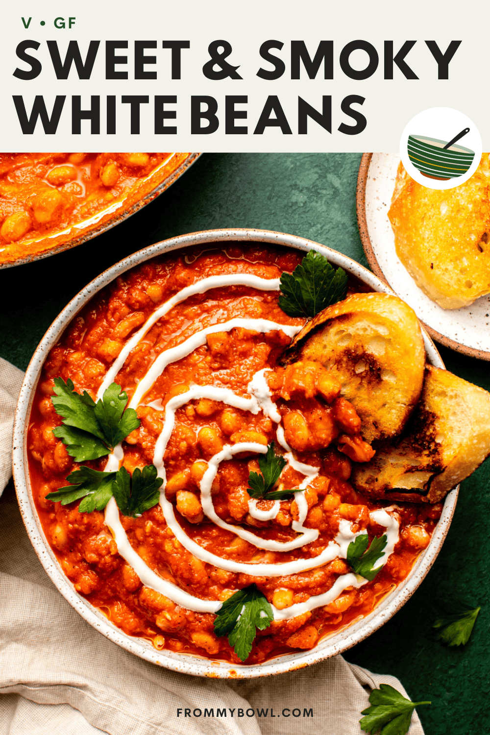 sweet and smoky white beans served in a wide plate topped with cashew cream, parsley and toasted slices of sourdough